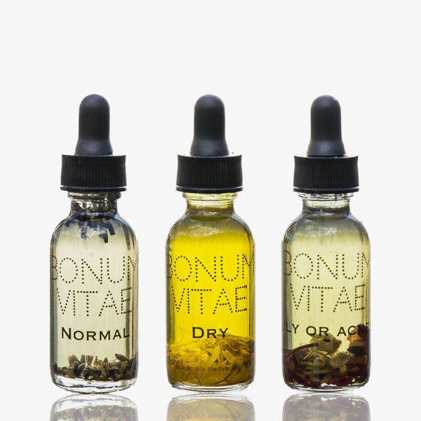 Three bottles of oil with different oils in them.